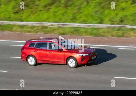 2023 Red MG 5 se 156 Electric 61 kWh Auto Car Estate elettricità 115 kW viaggiando a velocità sostenuta sull'autostrada M6 a Greater Manchester, Regno Unito Foto Stock