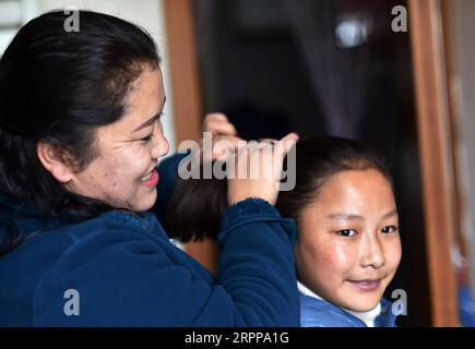 200314 -- LHASA, 14 marzo 2020 -- Pandor pettina i capelli di una ragazza in una casa per bambini a Lhasa, nella regione autonoma Tibet del sud-ovest della Cina, 11 marzo 2020. Pandor è nato a Shigatse, nella regione autonoma del Tibet della Cina sud-occidentale, una città vicino al confine con Nepal, Bhutan e India. È una madre orgogliosa di 22 figli, anche se la bambina di 37 anni non è mai stata incinta o sposata. Sei anni fa, Pandor si trasferì nella capitale regionale, Lhasa, dove trovò un lavoro in una casa per bambini per neonati fino agli studenti del college. La casa era alla ricerca di donne per gestire le unità familiari. Ci siamo divisi Foto Stock