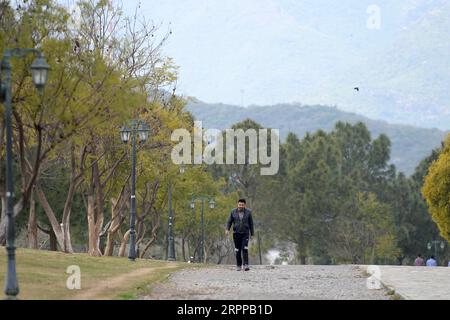 200314 -- ISLAMABAD, 14 marzo 2020 -- Un uomo cammina in un parco pubblico a Islamabad, capitale del Pakistan, 14 marzo 2020. Il governo del Pakistan ha annunciato di aggiornare le sue misure contro la COVID-19 in tutto il paese dopo che 28 persone sono risultate positive al virus negli ultimi 17 giorni, l'assistente speciale del primo ministro della salute Zafar Mirza ha detto ai media qui venerdì sera. Il paese ha vietato tutti i tipi di riunioni pubbliche, tra cui festival sportivi e culturali, incontri ricreativi nei cinema e nei teatri, cerimonie di matrimonio nelle sale o nei luoghi aperti, incontri con i prigionieri, truffe Foto Stock