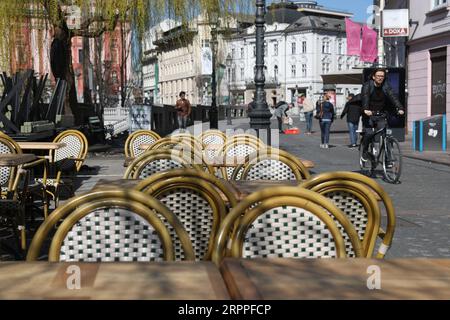 200317 -- LUBIANA, 17 marzo 2020 -- Un uomo passa davanti a sedie vuote di un ristorante accanto a una strada di Lubiana, capitale della Slovenia, 16 marzo 2020. Il numero di casi confermati di COVID-19 in Slovenia è salito a 253, secondo il governo lunedì. Il governo ha deciso di sospendere i trasporti pubblici da domenica mezzanotte e prorogare indefinitamente il precedente decreto sulla chiusura di tutte le istituzioni educative. SLOVENIA-LUBIANA-COVID-19 PengxLijun PUBLICATIONxNOTxINxCHN Foto Stock