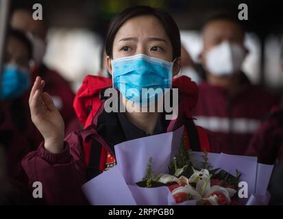 200317 -- WUHAN, 17 marzo 2020 -- Medic Zhang Durong dalla provincia di Guizhou della Cina sud-occidentale saluta alla stazione ferroviaria di Wuhan nella provincia di Hubei della Cina centrale, 17 marzo 2020. Alcune squadre di assistenza medica hanno iniziato a lasciare la provincia di Hubei martedì come l'epidemia nella provincia duramente colpita è stata sottomessa. CHINA-WUHAN-COVID-19-MEDICS-PARTENZA CN XIAOXYIJIU PUBLICATIONXNOTXINXCHN Foto Stock