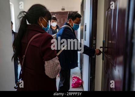 200320 -- KUNMING, 20 marzo 2020 -- Villager Yan Fugao e sua moglie Wang Daxiang arrivano nella loro nuova casa nell'area di reinsediamento di Maojiawan nella contea di Ludian, nella provincia dello Yunnan della Cina sud-occidentale, 15 marzo 2020. Immerso nelle montagne della provincia dello Yunnan, nella Cina sud-occidentale, il villaggio di Luoqiu ospita solo dozzine di famiglie sparse nella valle di montagna. Villager Yan Fugao e sua moglie Wang Daxiang vivono qui da più di 20 anni. Il duro ambiente montano qui ha fortemente limitato le attività economiche della popolazione locale e ha causato la povertà di alcuni di essi. La famiglia di Yan Fugao e' tra di loro, un Foto Stock