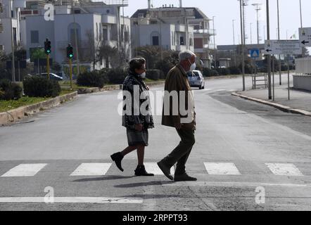 200321 -- ROMA, 21 marzo 2020 Xinhua -- persone che indossano maschere per il viso attraversano una strada a Ostia, Roma, Italia, 21 marzo 2020. L'Italia ha segnalato 6.557 nuovi casi di coronavirus sabato, portando il totale a 53.578 da quando la pandemia è scoppiata per la prima volta nel suo nord il 21 febbraio, secondo gli ultimi dati forniti dal Dipartimento della protezione civile che gestisce l'emergenza COVID-19. Foto di Elisa Lingria/Xinhua ITALIA-ROMA-OSTIA-COVID-19-CASES PUBLICATIONxNOTxINxCHN Foto Stock