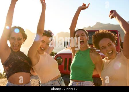 Ritratto delle amiche sorridenti in piedi in auto, divertendosi durante un viaggio in campagna Foto Stock