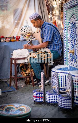 Laboratorio di artigianato marocchino, insieme a un lavoratore sullo sfondo, circondato dai loro prodotti. Fotografia scattata il 2 settembre 2023 nella città di Av Foto Stock