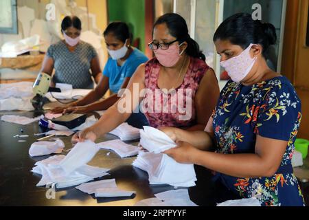 200323 -- COLOMBO, 23 marzo 2020 -- le donne fanno maschere facciali nelle loro case a Kaduwela, alla periferia della capitale dello Sri Lanka Colombo, 23 marzo 2020. Dieci nuovi pazienti sono risultati positivi al virus COVID-19 in Sri Lanka lunedì, portando il numero totale di infezioni nel paese a 91, ha detto il Ministero della salute in una dichiarazione. Il governo di lunedì scorso ha revocato il coprifuoco in distretti diversi da Colombo, Puttalam, la provincia nord-occidentale, il distretto nord e la periferia di Gampaha, per alcune ore per consentire alle persone di rifornirsi di articoli essenziali. Il coprifuoco è stato reimposto ag Foto Stock