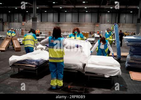 200324 -- MADRID, 24 marzo 2020 Xinhua -- il personale sanitario prepara i posti letto presso l'ospedale da campo allestito presso il centro espositivo IFEMA di Madrid, Spagna, 22 marzo 2020. Domenica hanno visto i primi pazienti arrivare all'ospedale da campo allestito presso il centro fieristico IFEMA di Madrid dai membri dell'unità di pronto intervento militare spagnolo. L'ospedale da campo alla fine avrà spazio per 5.500 posti letto e anche un'unità di terapia intensiva. SPAGNA FUORI. AMERICA LATINA FUORI. EFE/Handout via Xinhua SPAIN-MADRID-COVID-19-FIELD HOSPITAL PUBLICATIONxNOTxINxCHN Foto Stock