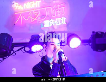 200324 -- CHONGQING, 24 marzo 2020 -- Un cantante si esibisce nel distretto di Jiangbei di Chongqing, nella Cina sud-occidentale, 23 marzo 2020. Nell’ambito di misure rigorose adottate per combattere la COVID-19, Chongqing ha riaperto bar, ristoranti e venditori di snack ai cittadini per stimolare la sua economia notturna in modo ordinato. CHINA-CHONGQING-COVID-19-NIGHT ECONOMY CN WANGXQUANCHAO PUBLICATIONXNOTXINXCHN Foto Stock