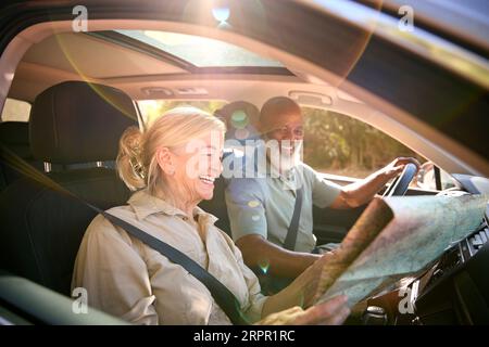 Coppia anziana in gita di un giorno con guida in auto, mappa di lettura Foto Stock