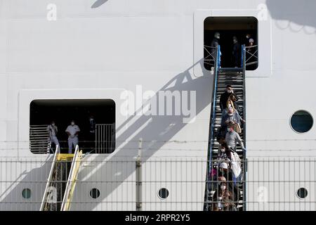 200325 -- LISBONA, 25 marzo 2020 -- i passeggeri che indossano maschere protettive sbarcano dalla nave da crociera MSC Fantasia al porto di Lisbona, Portogallo, 24 marzo 2020. Le autorità portoghesi hanno dichiarato domenica che tutti i passeggeri che sono arrivati a Lisbona a bordo di una nave da crociera dovranno sottoporsi a test di screening per la COVID-19, ha riferito Lusa News Agency. Secondo una dichiarazione del Ministero dell'Amministrazione interna mai, la nave da crociera MSC Fantasia dal Brasile è arrivata a Lisbona domenica presto con 1.338 passeggeri, di cui 27 cittadini portoghesi. Foto di /Xinhua PORTUGAL-LISBON-CRUIS Foto Stock