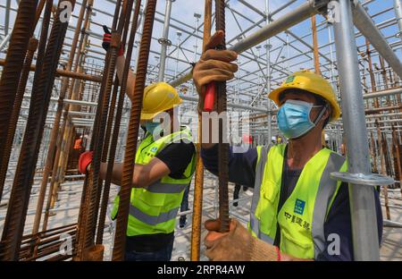 200326 -- WUHAN, 26 marzo 2020 -- i membri del personale lavorano in un cantiere a Wuhan, nella provincia di Hubei, Cina centrale, 26 marzo 2020. Un progetto a Wuhan intrapreso dal China Construction Third Engineering Bureau Co., Ltd ha ufficialmente ripreso i lavori mercoledì. Attualmente, più di 400 dirigenti e lavoratori sono tornati al cantiere e più di 500 lavoratori torneranno al lavoro la prossima settimana. Il 25 marzo l’applicazione della ripresa della costruzione è stata approvata dalla sede centrale di controllo della COVID-19 della zona di sviluppo ad alta tecnologia del lago orientale di Wuhan dopo un esame rigoroso. Il pr Foto Stock