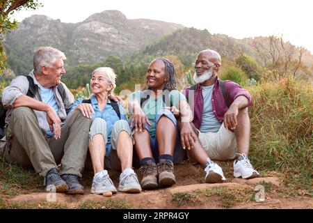 Amici anziani attivi che fanno Una pausa passeggiando insieme nella campagna Foto Stock