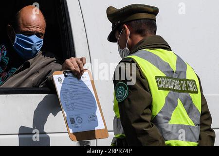 200328 -- SANTIAGO, 28 marzo 2020 Xinhua -- Un poliziotto controlla i documenti di un autista a Santiago, Cile, 27 marzo 2020. Il Cile ha adottato una quarantena progressiva per contribuire a controllare la diffusione della malattia nel paese, dove sono stati registrati 1.610 casi e cinque decessi. Il governo ha chiuso le frontiere e persino isolato alcune aree, ha installato cordoni sanitari e ha imposto il coprifuoco nazionale. Foto di Jorge Villegas/Xinhua CHILE-SANTIAGO-COVID-19-RESTRICTION PUBLICATIONxNOTxINxCHN Foto Stock