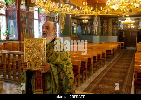 200330 -- BETLEMME, 30 marzo 2020 Xinhua -- Un sacerdote conduce una messa domenicale vuota in una chiesa ortodossa a Beit Sahour, vicino alla città di Betlemme in Cisgiordania, il 29 marzo 2020. Per la prima volta in assoluto, Raed al-Atrash, un palestinese di 54 anni della città di Betlemme della Cisgiordania, ha partecipato alla messa domenicale con la sua famiglia attraverso una trasmissione televisiva in diretta, mentre le chiese sono chiuse come parte delle precauzioni contro la diffusione del romanzo coronavirus. ANDARE CON la caratteristica: I cristiani in Palestina partecipano alle preghiere dal vivo mentre le chiese chiudono le paure del coronavirus foto di Luay Sababa/Xinhua MIDEAST-BETHLE Foto Stock