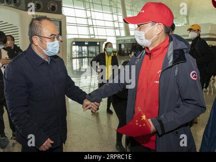 200331 -- WUHAN, 31 marzo 2020 -- Presidente del Wuhan Jinyintan Hospital Zhang Dingyu Front, L vede i membri di una squadra medica di Shanghai all'Aeroporto Internazionale di Wuhan Tianhe a Wuhan, provincia di Hubei, Cina centrale, 31 marzo 2020. Quasi 7.000 operatori medici provenienti da tutta la Cina hanno lasciato Wuhan martedì dopo aver terminato i loro compiti. CHINA-HUBEI-WUHAN-MEDICAL TEAMS-RETURN FROM HUBEI CN FEIXMAOHUA PUBLICATIONXNOTXINXCHN Foto Stock