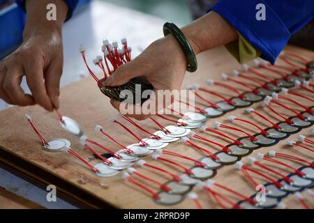 200401 -- RONGJIANG, 1 aprile 2020 -- Una donna lavora in un'impresa di elettronica nella contea di Rongjiang, nella provincia di Guizhou della Cina sud-occidentale, 1 aprile 2020. Come una delle nove contee colpite dalla povertà nella provincia di Guizhou che non sono state tolte dalla povertà, la contea di Rongjiang si è concentrata sulla promozione della ripresa della produzione di imprese nella contea e dell'esportazione di servizi di manodopera da febbraio. Fino ad ora, più di 140.000 persone sono state impiegate tra i 190.000 lavoratori esistenti nella contea di Rongjiang. CHINA-GUIZHOU-RONGJIANG-RIDUZIONE DELLA POVERTÀ CN YANGXYING PUBLICATIONXNOTXINXCH Foto Stock