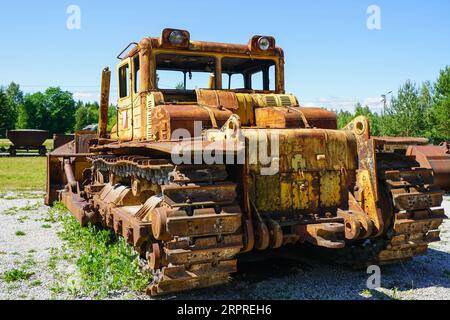 Vista posteriore di un grande bulldozer cingolato arrugginito vecchio e pesante, di un dozer per movimento terra abbandonato d'epoca, di macchinari industriali pesanti Foto Stock