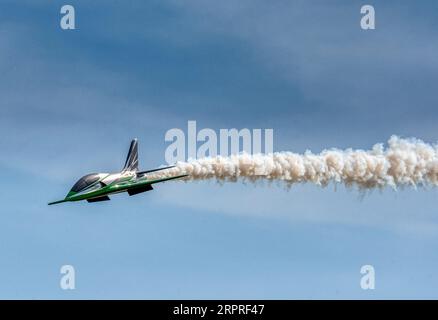 Un jet RC mette in moto una pista di fumo al Popham Airfield, alla mostra di modellini, a Popham, Hampshire, Regno Unito Foto Stock