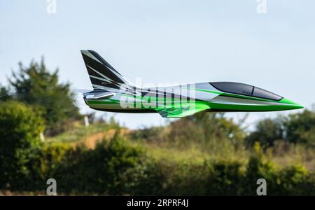 Un jet RC verde fa un salto in volo al Popham Airfield, al model airshow di Popham, Hampshire, Regno Unito Foto Stock