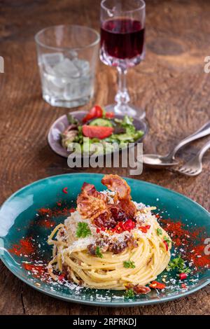 spaghetti alla carbonara con insalata su legno Foto Stock
