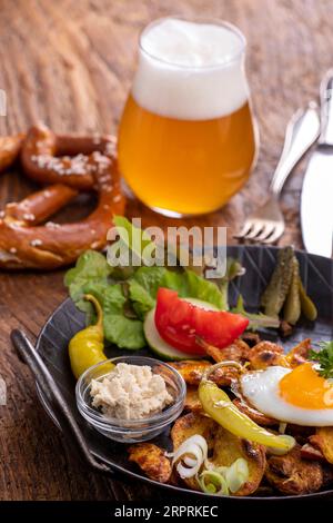piatto di patate austriaco su legno con birra Foto Stock