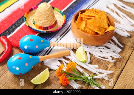 Poncho con cibo e simboli messicani per il giorno dell'indipendenza su sfondo di legno, primo piano Foto Stock