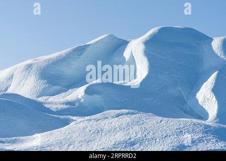 Primo piano di un imponente iceberg galleggiante sotto il sole artico nel fiordo ghiacciato di Ilulissat, patrimonio dell'umanità dell'UNESCO. Ilulissat, Groenlandia Foto Stock