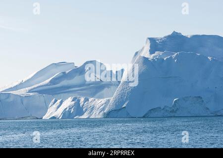 Impressionanti iceberg galleggianti al sole artico nel fiordo di Ilulissat, sito patrimonio dell'umanità dell'UNESCO, vicino a Ilulissat. Disko Bay, Avanaata, Groenlandia Foto Stock