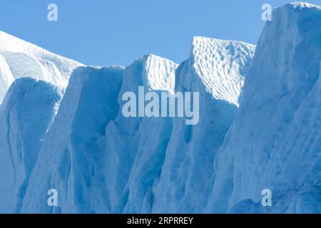 Primo piano di un imponente iceberg galleggiante sotto il sole artico nel fiordo ghiacciato di Ilulissat, patrimonio dell'umanità dell'UNESCO. Ilulissat, Groenlandia Foto Stock