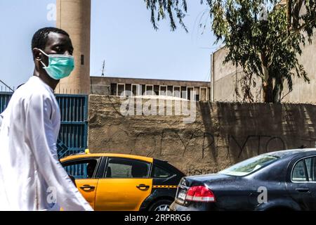 200407 - DAKAR, 7 aprile 2020 Xinhua - Un uomo che indossa una maschera facciale è visto in una strada a Dakar, in Senegal, il 7 aprile 2020. Il Ministero senegalese della salute e dell'azione sociale ha dichiarato martedì che altri 13 pazienti sono stati curati dal COVID-19, portando il numero totale di pazienti curati nel paese a 105. Il ministro della salute senegalese Aboudulaye Diouf Sarr ha anche detto che il totale dei casi confermati del paese è stato a 237. Tra i 237 casi confermati, 85 sono stati importati. Foto di Eddy Peters/Xinhua SENEGAL-DAKAR-COVID-19-CASES PUBLICATIONxNOTxINxCHN Foto Stock