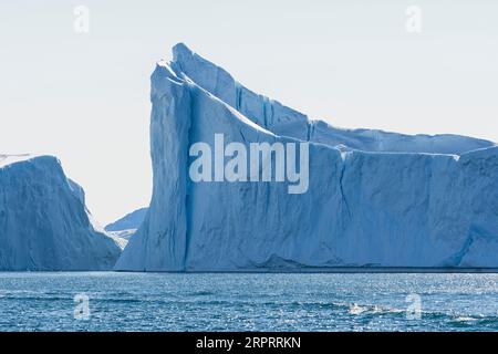 Imponenti iceberg galleggianti sotto il sole artico nel fiordo ghiacciato Ilulissat, patrimonio dell'umanità dell'UNESCO. Ilulissat, Avanaata, Groenlandia, Danimarca Foto Stock