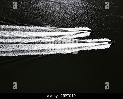Vista aerea con droni dall'alto verso il basso di due motoscafi e si risveglia Foto Stock
