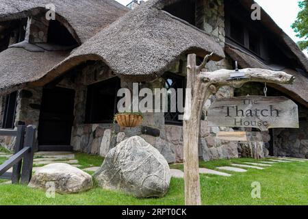 La Thatch House, una delle Case dei funghi, progettata dall'architetto Earl Young nel XX secolo, con tetto in paglia il 24 agosto 2023 a Charlevoix, M. Foto Stock