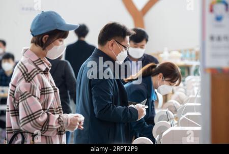 200410 -- SEOUL, 10 aprile 2020 Xinhua -- gli elettori che indossano maschere e guanti usa e getta aspettano di lanciare le loro schede elettorali in una sede elettorale a Seoul, Corea del Sud, 10 aprile 2020. Un voto di due giorni in anticipo per le elezioni dell'Assemblea Nazionale della Corea del Sud, che si svolgerà il 15 aprile, è iniziato venerdì. Poiché la sicurezza pubblica è una priorità fondamentale per le elezioni di quest'anno in occasione della pandemia di COVID-19, si consiglia agli elettori di indossare maschere e di votare dopo aver utilizzato disinfettanti per le mani e indossato guanti usa e getta. La Corea del Sud ha riportato 27 casi in più di COVID-19 rispetto a 24 ore fa a metà Foto Stock