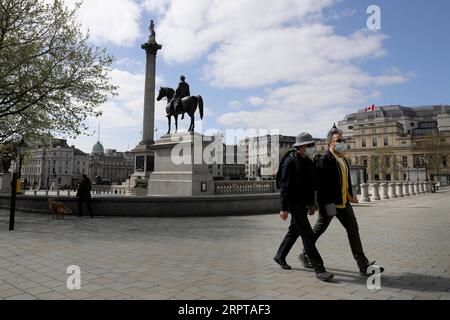200413 -- LONDRA, 13 aprile 2020 Xinhua -- le persone che indossano maschere camminano attraverso Trafalgar Square a Londra, in Gran Bretagna, 13 aprile 2020. Il bilancio delle vittime di coloro che sono stati ricoverati in Gran Bretagna che sono risultati positivi per il nuovo coronavirus ha raggiunto 10.612 a partire da sabato pomeriggio, il Dipartimento di salute e assistenza sociale ha detto domenica. Foto di Tim Ireland/Xinhua BRITAIN-LONDON-COVID-19-DEATH TOLL PUBLICATIONxNOTxINxCHN Foto Stock