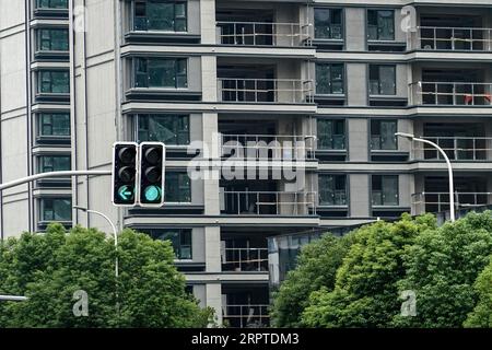 Un semaforo è illuminato di fronte a un edificio residenziale in costruzione. Sia i mercati delle case nuove che quelli delle case usate hanno visto aumentare l'attività di mercato durante il fine settimana dopo tutte e quattro le città di primo livello, ossia Pechino, Shanghai, Guangzhou e Shenzhen, politiche semplificate sugli acquisti di immobili residenziali.secondo le nuove politiche, le famiglie in quelle città con record ipotecari ma nessuna proprietà locale di immobili saranno trattate come acquirenti di case per la prima volta, ammissibili a pagamenti agevolati e tassi ipotecari più bassi. (Foto di Sheldon Cooper/SOPA Images/Sipa USA) Foto Stock