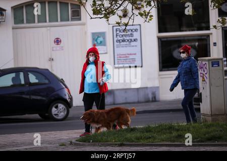 200416 -- BRUXELLES, 16 aprile 2020 -- Un cittadino che indossa una maschera cammina il suo cane a Bruxelles, Begium, 14 aprile 2020. Mercoledì il primo ministro belga Sophie Wilmes ha annunciato un'estensione del confinamento fino al 3 maggio per frenare la diffusione del coronavirus. BELGIO-BRUXELLES-COVID-19-LOCKDOWN-EXTENTION ZhangxCheng PUBLICATIONxNOTxINxCHN Foto Stock