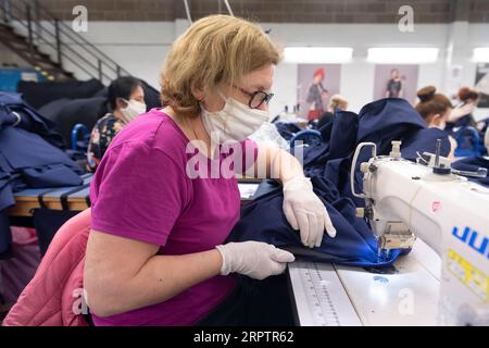 200417 -- LONDRA, 17 aprile 2020 -- Un macchinista cuce abbigliamento medico per il NHS National Health Service presso la fabbrica Fashion-Enter Ltd, a Londra, in Gran Bretagna, 17 aprile 2020. Il governo britannico continua a cercare di combattere l'epidemia di COVID-19, con molti produttori di abbigliamento in tutto il paese che si rivolgono per produrre attrezzature mediche per il NHS. Foto di /Xinhua BRITAIN-LONDON-COVID-19-MEDICAL SUPPLY RayxTang PUBLICATIONxNOTxINxCHN Foto Stock