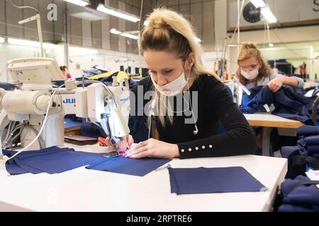 200417 -- LONDRA, 17 aprile 2020 -- Un macchinista cuce abbigliamento medico per il NHS National Health Service presso la fabbrica Fashion-Enter Ltd, a Londra, in Gran Bretagna, 17 aprile 2020. Il governo britannico continua a cercare di combattere l'epidemia di COVID-19, con molti produttori di abbigliamento in tutto il paese che si rivolgono per produrre attrezzature mediche per il NHS. Foto di /Xinhua BRITAIN-LONDON-COVID-19-MEDICAL SUPPLY RayxTang PUBLICATIONxNOTxINxCHN Foto Stock