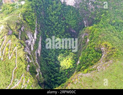 200419 -- LEYE, 19 aprile 2020 -- foto aerea scattata il 19 aprile 2020 mostra lo scenario di Dashiwei Tiankeng, una dolina carsica gigante, al Leye-Fengshan Global Geopark, nella regione autonoma Guangxi Zhuang della Cina meridionale. Il Leye-Fengshan Geopark è stato aggiunto alla lista globale dei Geoparchi dell'UNESCO nel 2010. Il geopark contiene grandi fiumi sotterranei, ponti naturali e vasti sistemi di grotte. CHINA-GUANGXI-LEYE-GEOPARK CN ZhouxHua PUBLICATIONxNOTxINxCHN Foto Stock