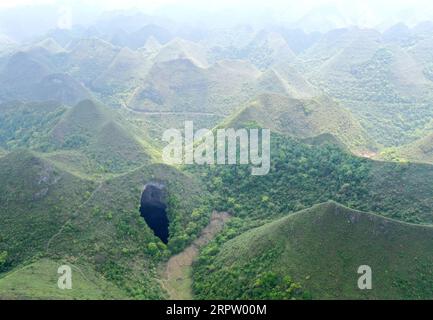 200419 -- LEYE, 19 aprile 2020 -- foto aerea scattata il 19 aprile 2020 mostra un Tiankeng, o dolina carsica gigante, al Leye-Fengshan Global Geopark, nella regione autonoma del Guangxi Zhuang della Cina meridionale. Il Leye-Fengshan Geopark è stato aggiunto alla lista globale dei Geoparchi dell'UNESCO nel 2010. Il geopark contiene grandi fiumi sotterranei, ponti naturali e vasti sistemi di grotte. CHINA-GUANGXI-LEYE-GEOPARK CN ZhouxHua PUBLICATIONxNOTxINxCHN Foto Stock