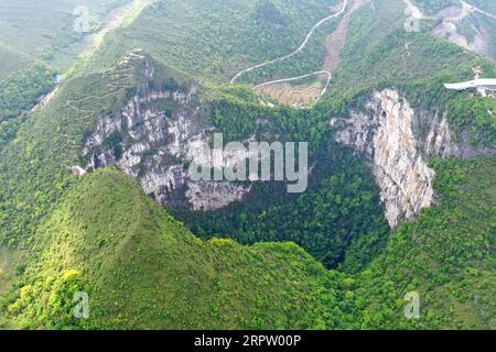 200419 -- LEYE, 19 aprile 2020 -- foto aerea scattata il 19 aprile 2020 mostra lo scenario di Dashiwei Tiankeng, una dolina carsica gigante, al Leye-Fengshan Global Geopark nella regione autonoma del Guangxi Zhuang nella Cina meridionale. Il Leye-Fengshan Geopark è stato aggiunto alla lista globale dei Geoparchi dell'UNESCO nel 2010. Il geopark contiene grandi fiumi sotterranei, ponti naturali e vasti sistemi di grotte. CHINA-GUANGXI-LEYE-GEOPARK CN ZhouxHua PUBLICATIONxNOTxINxCHN Foto Stock