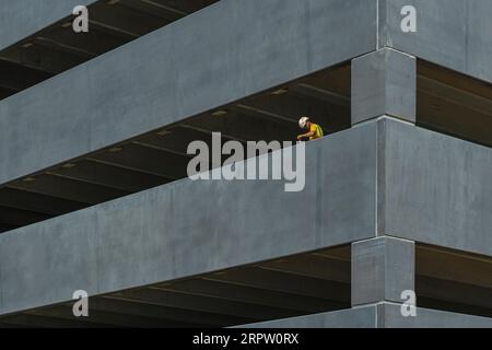 Operaio edile che dipinge un nuovo parcheggio auto, Baltimore Maryland USA Foto Stock