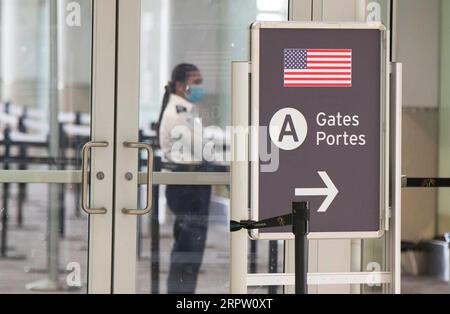 200420 -- PECHINO, 20 aprile 2020 -- Un membro dello staff della Canadian Air Transport Security Authority CATSA è in servizio senza viaggiatori ai cancelli di sicurezza per l'area di check-in degli Stati Uniti presso l'aeroporto internazionale Pearson di Toronto, Canada, il 18 aprile 2020. Il primo ministro canadese Justin Trudeau ha affermato che il Canada e gli Stati Uniti hanno convenuto di estendere le restrizioni transfrontaliere a tutti i viaggi non essenziali per altri 30 giorni per prevenire l'ulteriore diffusione della COVID-19. Foto di /Xinhua XINHUA FOTO DEL GIORNO ZouxZheng PUBLICATIONxNOTxINxCHN Foto Stock