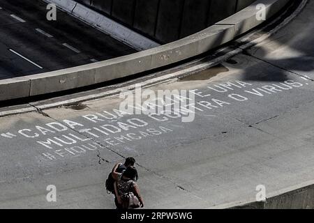 200422 -- SAO PAULO, 22 aprile 2020 Xinhua -- la gente passa per uno slogan artistico scritto in portoghese che significa che ogni strada vuota è una folla contro il virus rimani a casa in mezzo alla pandemia di COVID-19 a San Paolo, in Brasile, il 21 aprile 2020. Xinhua/Rahel Patrasso BRAZIL-SAO PAULO-ARTISTS-SLOGAN-COVID-19 PUBLICATIONxNOTxINxCHN Foto Stock