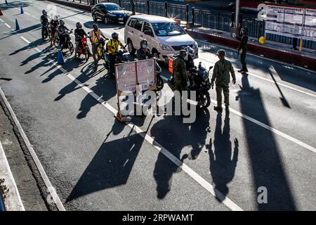 200424 -- MANILA, 24 aprile 2020 Xinhua -- poliziotti della polizia nazionale filippina PNP ispezionano gli automobilisti in un posto di blocco a Manila, nelle Filippine, 24 aprile 2020. Venerdì il governo filippino ha annunciato che un confinamento a Metro Manila e nelle province dell'isola principale di Luzon con un gran numero di nuove infezioni da coronavirus rimarrà in vigore fino al 15 maggio. Xinhua/Rouelle Umali FILIPPINE-MANILA-COVID-19-LOCKDOWN PUBLICATIONxNOTxINxCHN Foto Stock