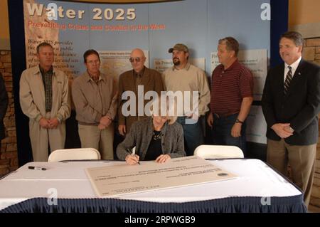 Segretario Gale Norton, centro, firma su Water 2025 Challenge Grant per la Payson City-Strawberry Highline Canal Company dello Utah, durante la cerimonia a Orem, Utah, segnando l'introduzione di finanziamenti federali per 11 progetti di gestione dell'acqua nello Utah e uno nell'Idaho. Water 2025 promuove banche d'acqua volontarie, nuove tecnologie e federali, statali, tribali, collaborazione privata per la conservazione Foto Stock