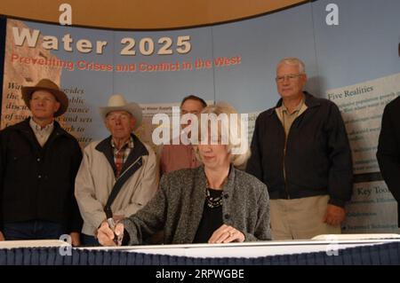 Segretario Gale Norton, centro, firmando Water 2025 Challenge Grant per il distretto di irrigazione di Springville nello Utah, durante la cerimonia a Orem, Utah, segnando l'attuazione di finanziamenti federali per 11 progetti di gestione dell'acqua nello Utah e uno nell'Idaho. Water 2025 promuove banche idriche volontarie, nuove tecnologie di conservazione e federali, statali, tribali, cooperazione privata in materia di conservazione Foto Stock