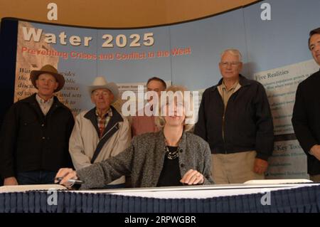 Segretario Gale Norton, centro, firmando Water 2025 Challenge Grant per il distretto di irrigazione di Springville nello Utah, durante la cerimonia a Orem, Utah, segnando l'attuazione di finanziamenti federali per 11 progetti di gestione dell'acqua nello Utah e uno nell'Idaho. Water 2025 promuove banche idriche volontarie, nuove tecnologie di conservazione e federali, statali, tribali, cooperazione privata in materia di conservazione Foto Stock