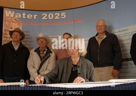 Segretario Gale Norton, centro, firmando Water 2025 Challenge Grant per il distretto di irrigazione di Springville nello Utah, durante la cerimonia a Orem, Utah, segnando l'attuazione di finanziamenti federali per 11 progetti di gestione dell'acqua nello Utah e uno nell'Idaho. Water 2025 promuove banche idriche volontarie, nuove tecnologie di conservazione e federali, statali, tribali, cooperazione privata in materia di conservazione Foto Stock